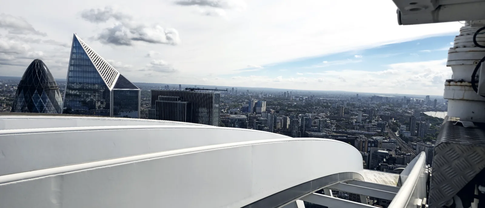 Looking out over the London skyline from a rooftop, access steelwork in the foreground