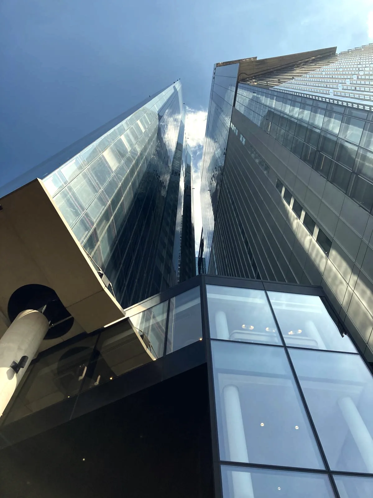 Glass towers rising against the sky, seen from street level