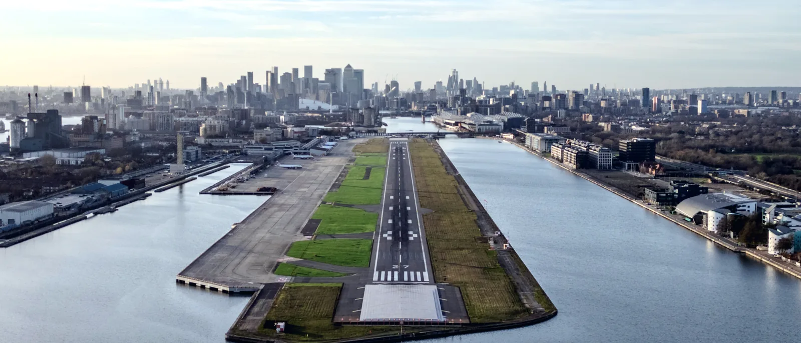 The City of London skyline rising behind an airport runway