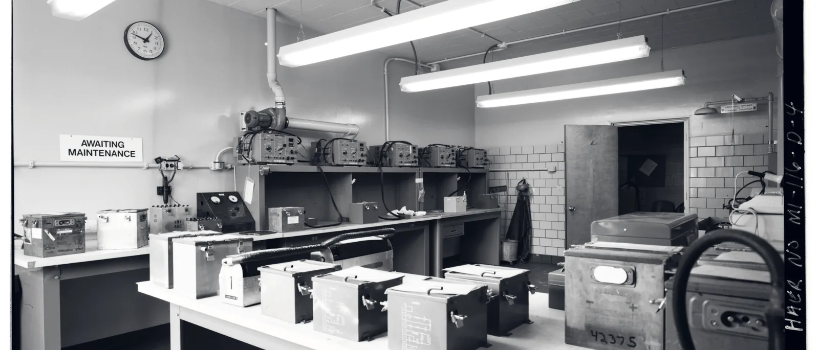 A vintage battery charging room lined with industrial workbenches