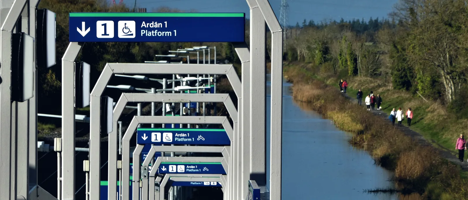 Accessible platform signage with a wheelchair icon along a covered walkway