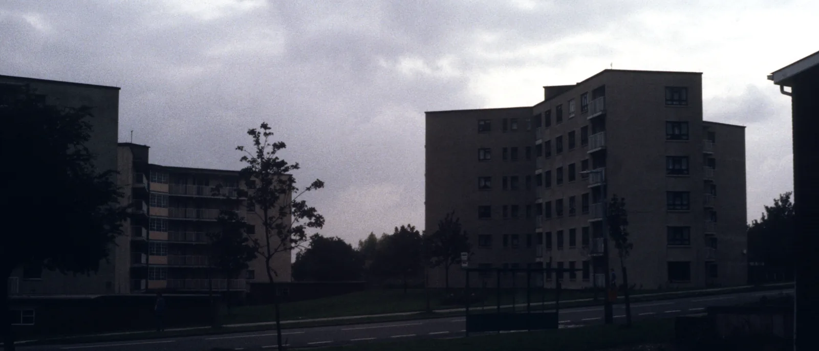 1960s system-built tower blocks on a UK housing estate at dusk
