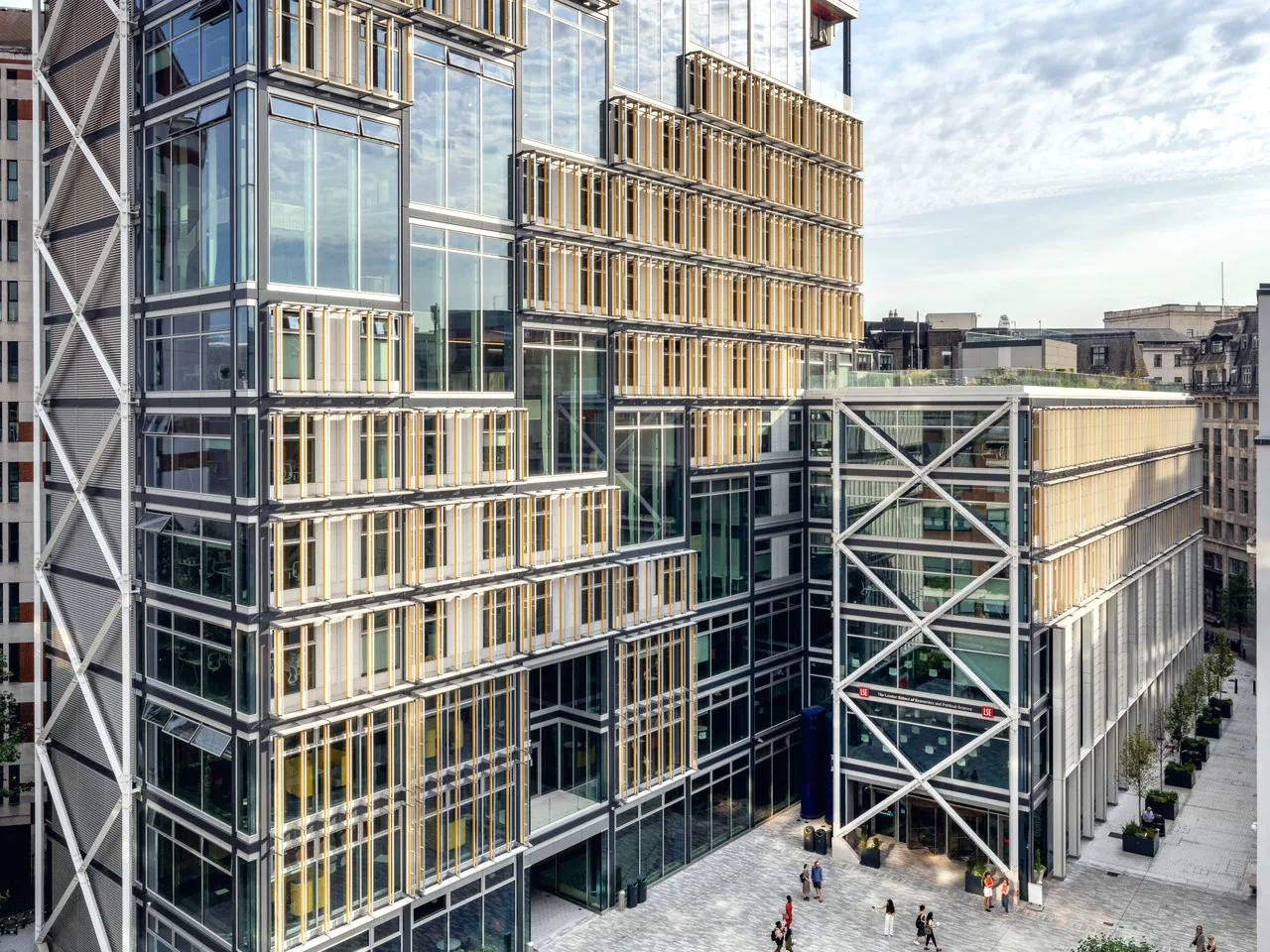 A modern glass and steel public building overlooking a paved city square