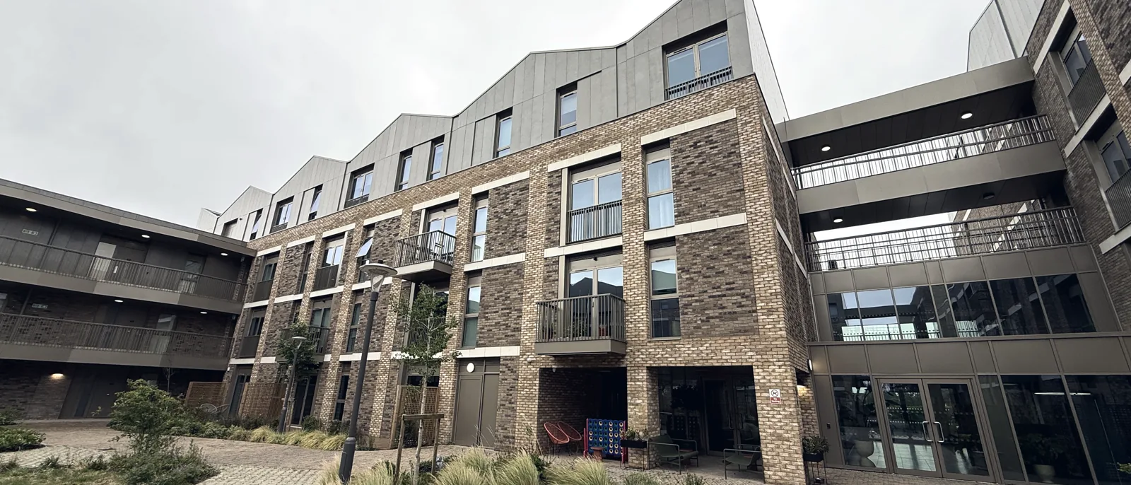 A new-build residential courtyard with landscaping between the blocks